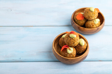 Falafel with guacamole on blue wooden. Side view, copy space.