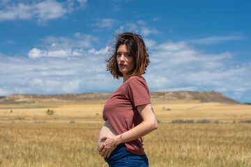 Young beautiful pregnant woman relaxing and enjoying life in nature