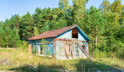 Fototapeta na wymiar Old Abandoned Wooden House on the Edge of the Forest