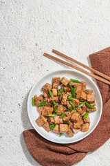 Fried teriyaki Tofu with scallions and sesame seeds. Healthy vegan meatless meal rich in protein