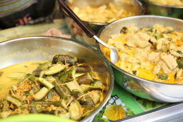 selling thai Green curry with meatballs, eggplant , coconut shoots and bamboo shoots in the market