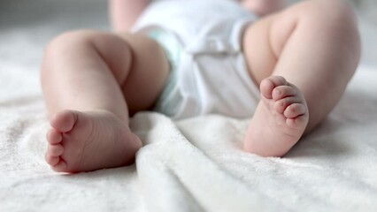 close up baby body parti cute hand fingers legs sole sitting on bed blanket. mother kissing infant toddler feet massage with hands. child moving uncontrollably.motherhood concept advertising 4k