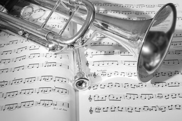 A view of the musical instrument which is the trumpet against the background of the sheet music