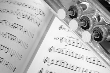 A view of the musical instrument which is the trumpet against the background of the sheet music