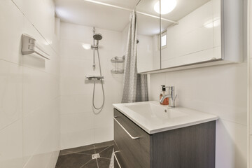 a bathroom with white walls and wood flooring in the shower area, while it appears to be used as a sink