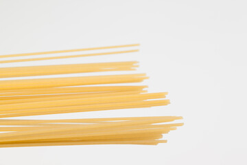 Spaghetti spread out on a white surface.