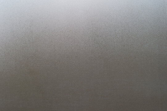 Water drops on fogged glass with a gray brightness gradient. Background