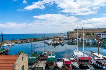 Landmarks of Kyrenia or Girne old town in Northern Cyprus. Medieval fortress and boats in harbour.