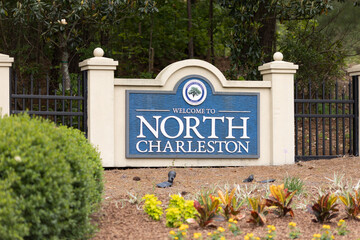 Fototapeta premium North Charleston, South Carolina city limits welcome sign with trees and flowers off of interstate I-26 in South Carolina
