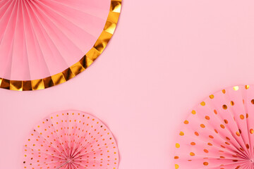 Paper fans on a pink background. Creative festive concept with copy space.
