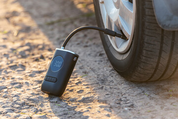 Inflating car tires with a portable wireless air pump outdoor