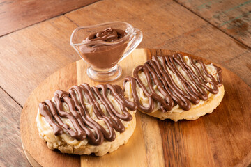 chocolate cream waffle with hazelnut and white chocolate on a wooden board on a rustic table