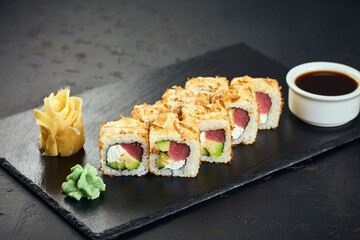 Sushi roll with tuna, avocado, cream cheese and tuna shavings on dark background. Sushi menu. Japanese food.
