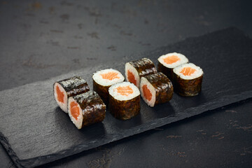 Roll with salmon on dark background. Sushi menu. Japanese food.
