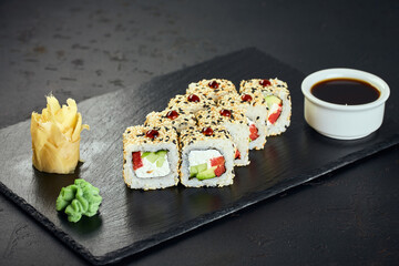 Sushi rolls with cucumber, red bell pepper and sesame on dark background. Sushi menu. Japanese food.