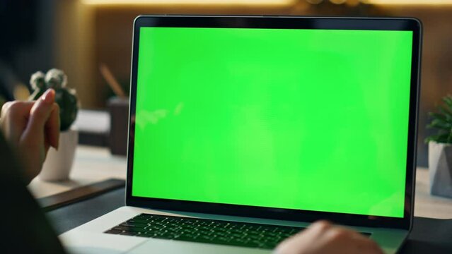 Greenscreen laptop user videocalling at desk close up. Boss video conference