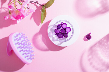 Scalp Massage and Cleansing Shampoo Brush with hair vitamins on pink background