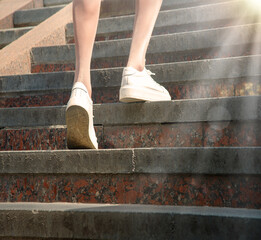 Fototapeta na wymiar Feet in sneakers going up the stairs