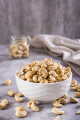 Delicious dried raw cashews in a bowl on the table for a plant based diet vertical view