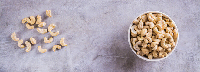 Dried cashew nuts in a bowl on the table for a vegetarian diet  top view web banner