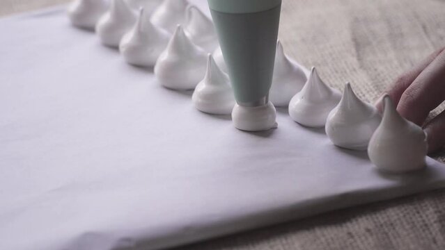 close up on tip of pastry bag making meringues