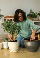 Woman grows potted plants at home watering and take care flowers - gardening and houseplant care concept