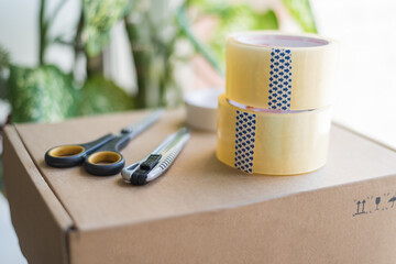 boxes for moving and delivery as well as scotch tape and an office knife with scissors