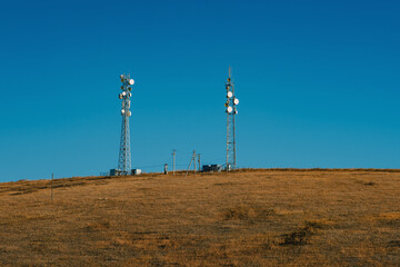 Telecommunication tower with lots of different antenna on the hill