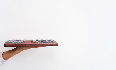 Yogi woman's hand holds a wooden sadhu board with sharp nails. Alternative medicine. Copy space.