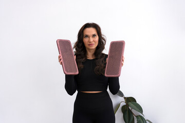 Female nail-standing coach wearing black sport suit holding sadhu boards for standing on nails.