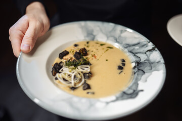 hands holding a plate with a spoon