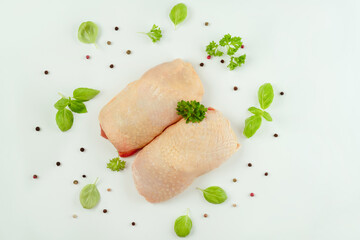 Chicken leg meat.Raw fresh chicken leg meat with skin and with fresh herbs on a white...