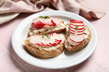 Plate with delicious radish bruschettas on pink tiled table