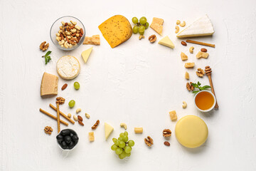 Fototapeta na wymiar Frame made of different types of tasty cheese, nuts and honey on light background