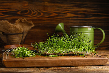 Board with fresh micro green on wooden background