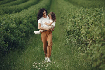 Mother with daughter playing in a summer field