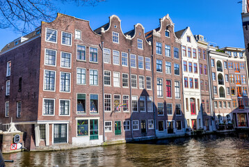 Fototapeta na wymiar Amsterdam, Netherlands - March 28, 2023: Iconic houses along the streets and canals of Amsterdam 