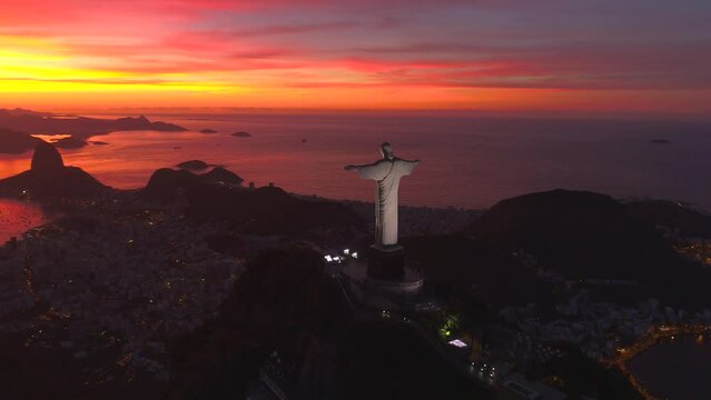 RIO DE JANEIRO, BRASIL - MAY, 2023: Drone aerial view of of a famous landmark Christ the Redeemer statue on Corcovado mauntain at sunrise. most visited tourist site in Rio at sunny day from above.