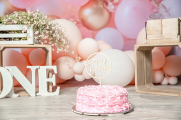 pink and white decoration for a 1st birthday cake smash studio photo shoot with balloons, paper decor, cake and topper. High quality photo
