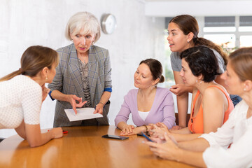 Obraz premium Female team leader holding meeting with group of fellow students, explaining details of new study project