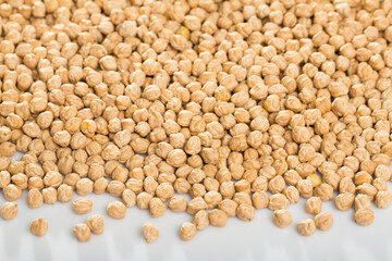 Fototapeta premium Natural background of dried chickpea seeds on white surface. Healthy eating..