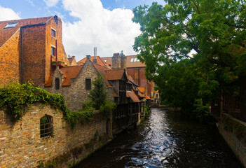 Fototapeta na wymiar Stone buildings along canal in Bruges, Belgium. Capital of province of West Flanders.
