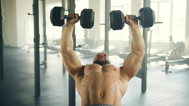 Process of dumbbell bench press done by man with naked muscular torso. High quality 4k footage