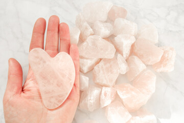 gua sha. Rose quartz massage scraper in the shape of a heart from natural stone on rose quartz on...