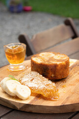 banana honey cake with wild honeycomb and banana slices on rustic wooden table background garden