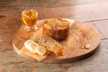 banana honey cake with wild honeycomb and banana slices on rustic wooden table