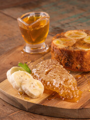 banana honey cake with wild honeycomb and banana slices on rustic wooden table in macro close-up