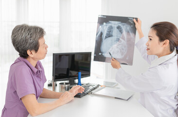 Obraz premium close up patient, asian patient looking film, she talk with doctor about symptoms and treatment plan, broken bone treatment, tuberculosis screening