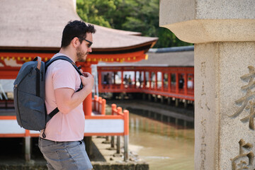 European tourist visiting Itsukushima Jinja in Miyajima, Hiroshima, Japan.