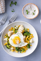 Healthy breakfast bowl with cooked vegetables and fried egg